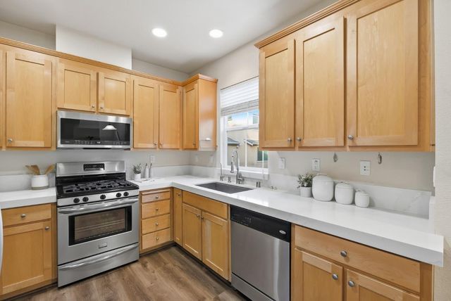 a kitchen with granite countertop a sink stainless steel appliances and cabinets