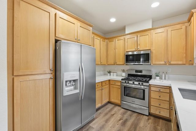 a kitchen with stainless steel appliances a refrigerator stove and sink