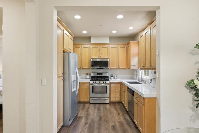 a kitchen with stainless steel appliances granite countertop a stove a sink and a refrigerator