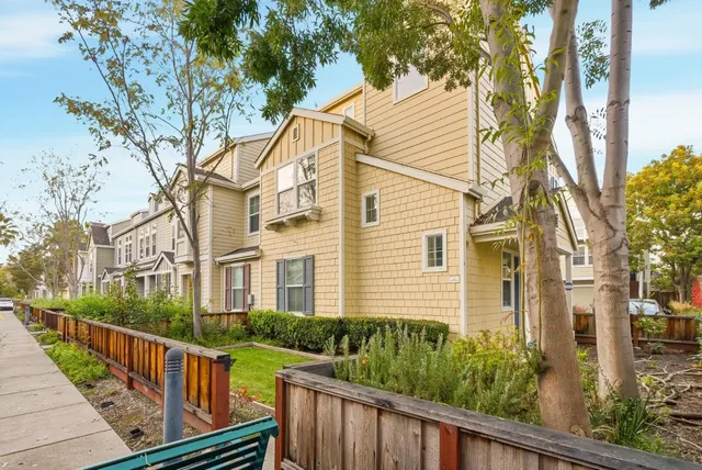 a view of a house with a small yard and wooden fence
