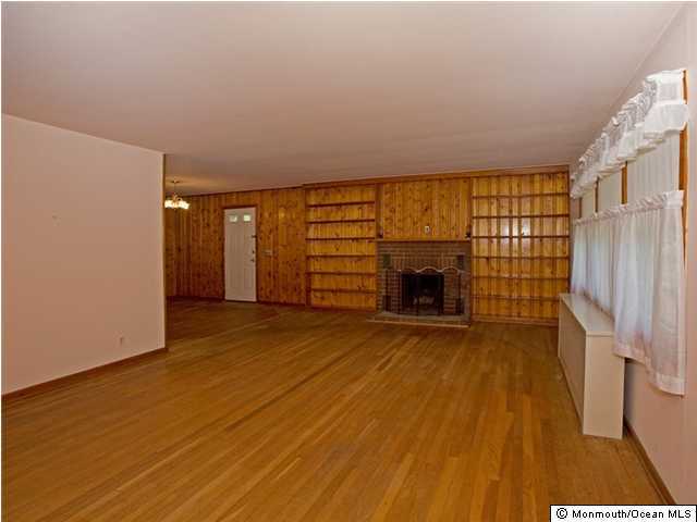 707 Lloyd Road Aberdeen, NJ 07747 - Photo 3 of 3 a view of empty room with a fireplace and wooden floor