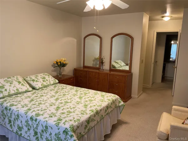 a bedroom with a bed and a dresser with mirror