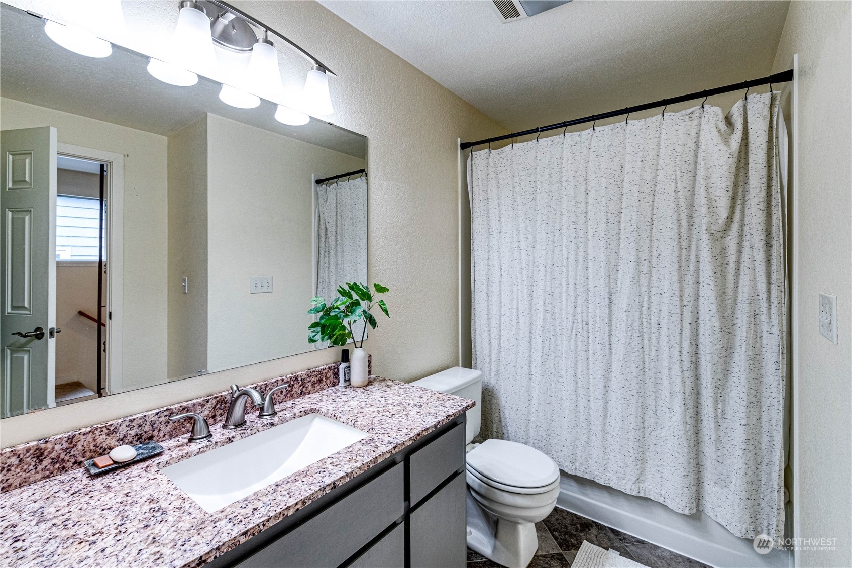 924 North 86th Street Seattle, WA 98103 - Photo 18 of 27 a bathroom with a granite countertop sink and a mirror