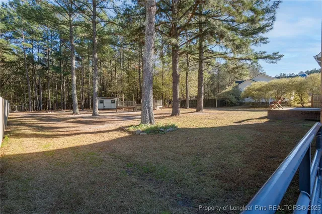 a view of a house with backyard and trees