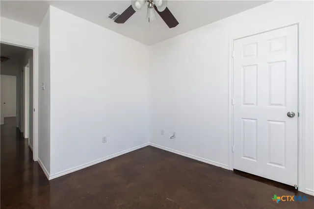 an empty room with a ceiling fan