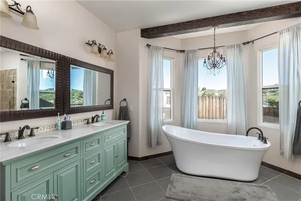 a spacious bathroom with a double vanity sink mirror and bathtub