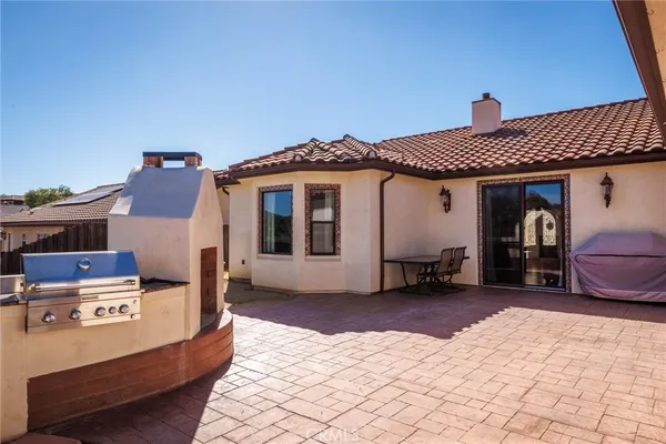 a front view of a house with barbeque grill and furniture