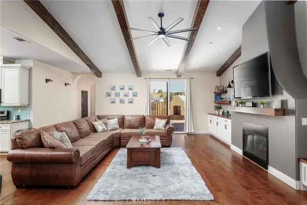 a living room with stainless steel appliances granite countertop furniture wooden floor and a view of kitchen