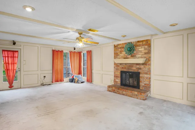 a view of an empty room with window and fireplace