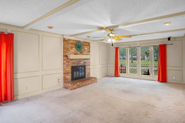 a view of an empty room with a fireplace and a window