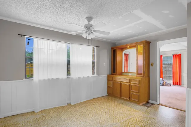 a view of an empty room with window and cabinet