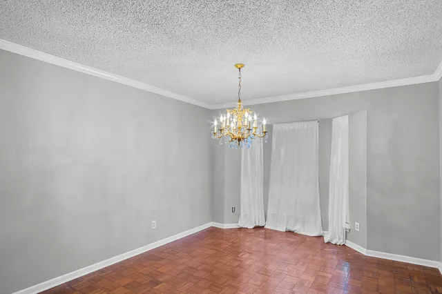a view of an empty room with a chandelier fan