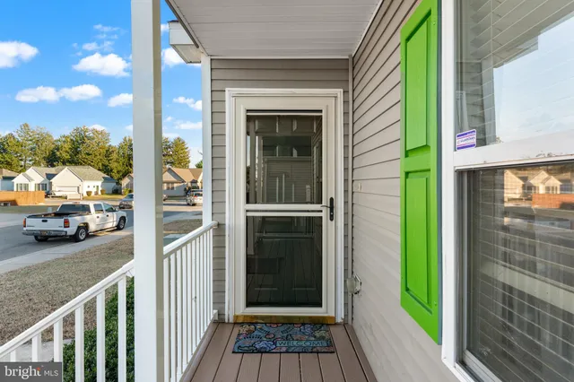 a view of a door and a car parked in front of a house