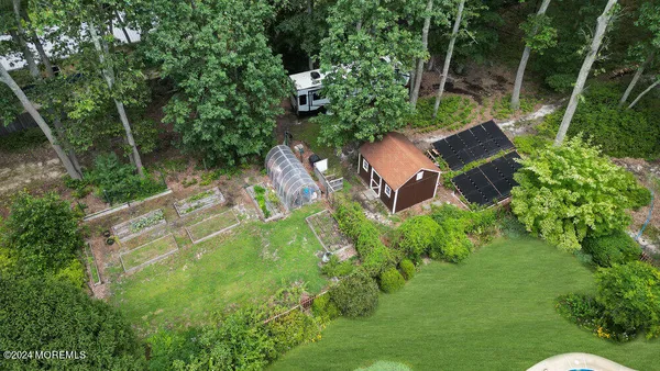 an aerial view of residential house with outdoor space and trees all around