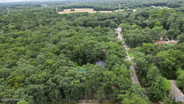 an aerial view of residential house with outdoor space and trees all around