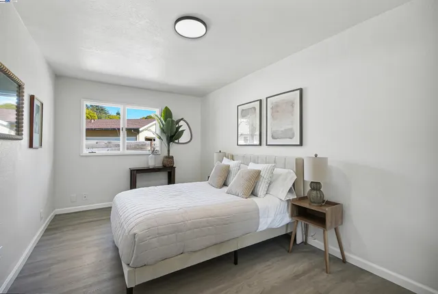 a bedroom with a bed and painting on the wall