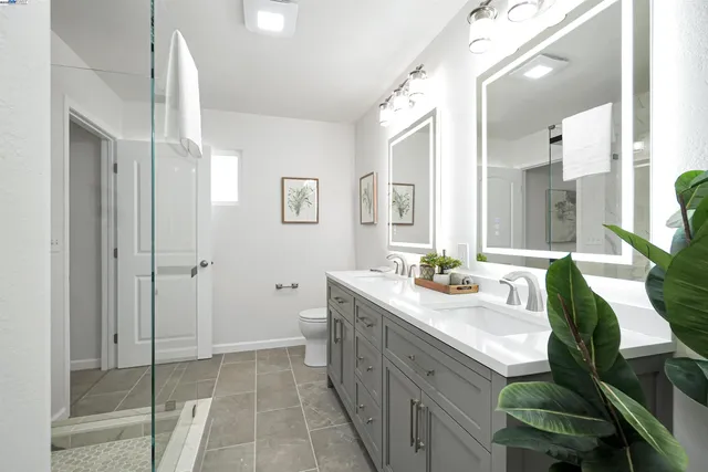 a bathroom with a granite countertop shower sink and mirror