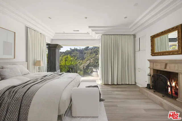 a bed sitting in a spacious bedroom next to a window