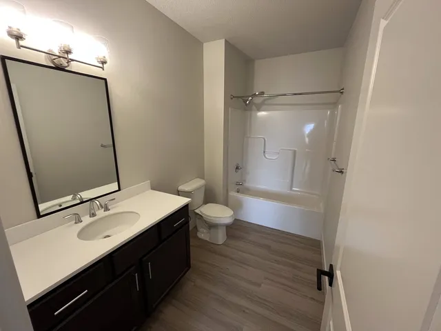 a bathroom with a sink a toilet a shower and a mirror