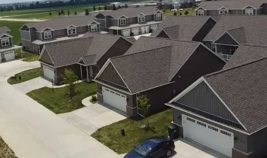 an aerial view of a house with a garden and lake view