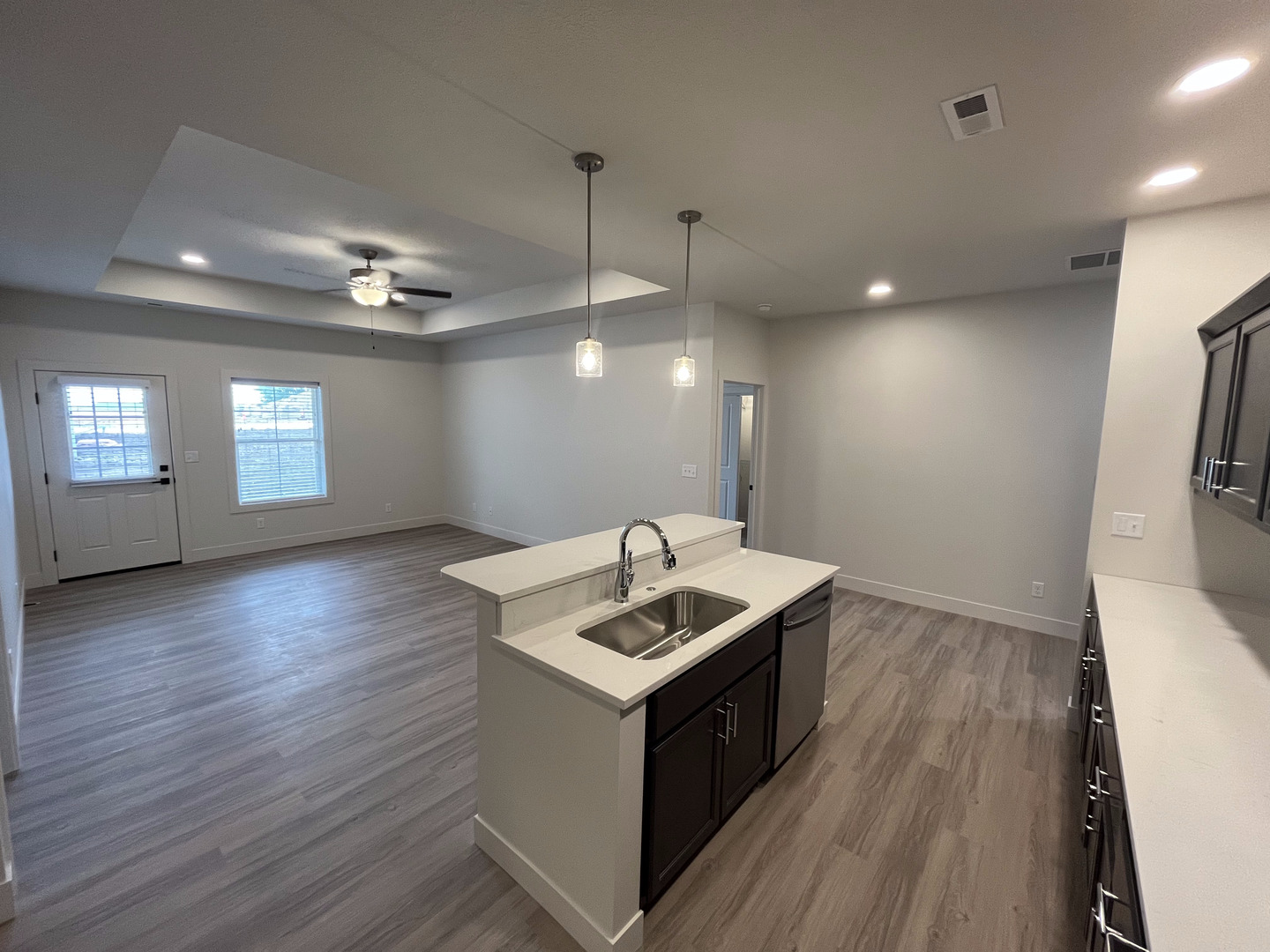 1150 Vision Circle Mahomet, IL 61853 - Photo 7 of 12 a kitchen that has a sink a microwave oven a stove and white cabinets with wooden floor