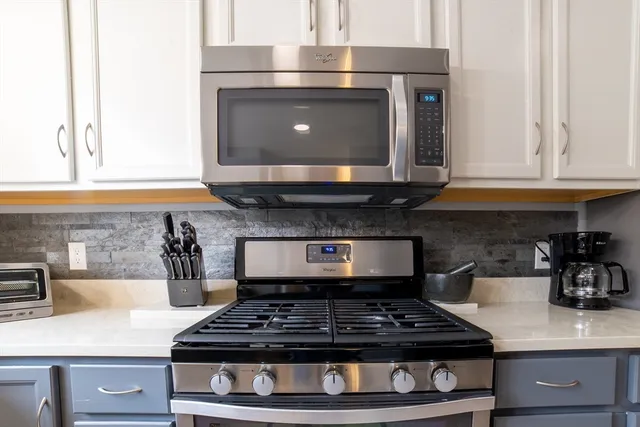 a kitchen with stainless steel appliances granite countertop a refrigerator a stove and a sink