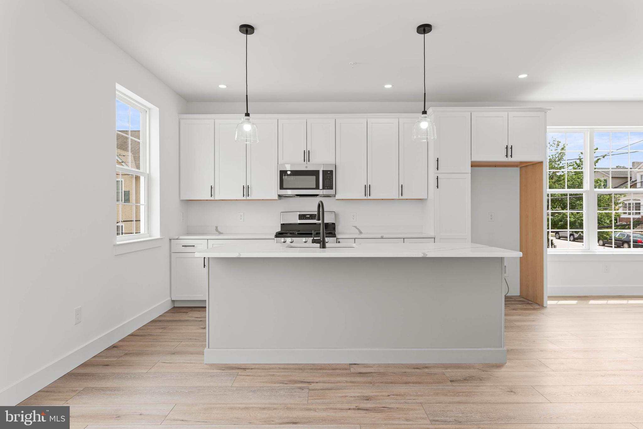 211 8th Street Bridgeport, PA 19405 - Photo 3 of 17 a kitchen with kitchen island a sink a center island stainless steel appliances and a window