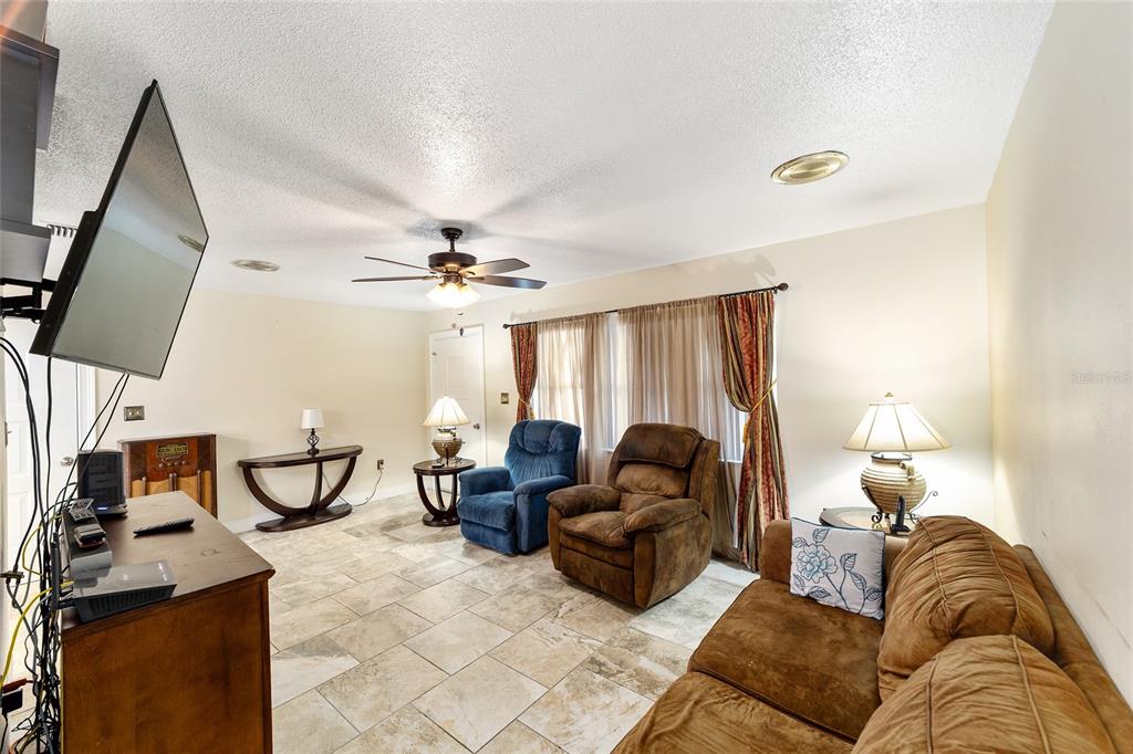 11 Brook Place Ocala, FL 34472 - Photo 6 of 27 a living room with furniture a fireplace and a flat screen tv