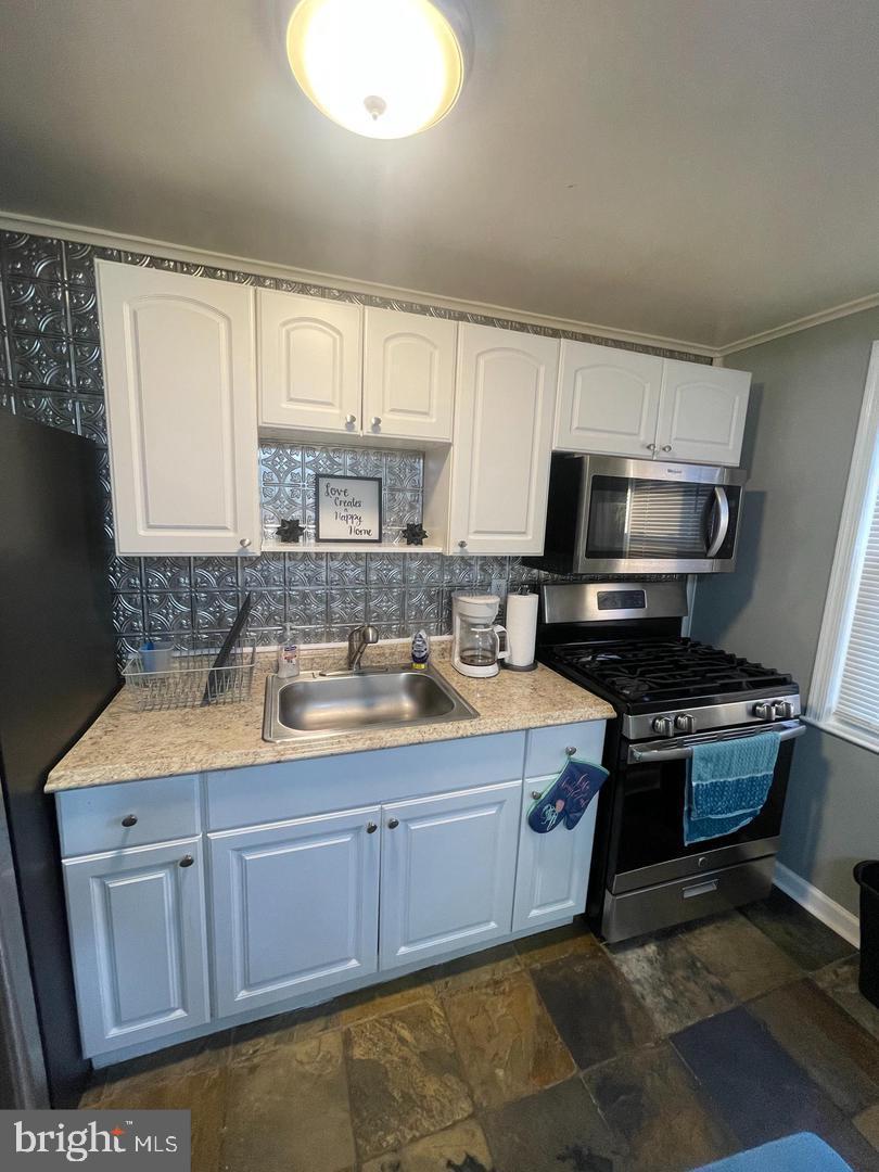 3654 Clarenell Road Baltimore, MD 21229 - Photo 4 of 15 a kitchen with stainless steel appliances granite countertop a sink stove and microwave