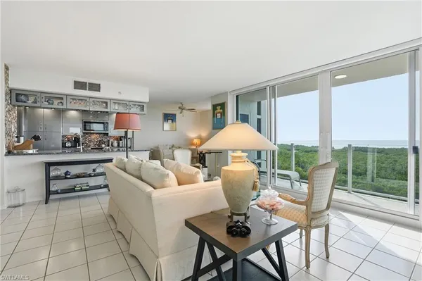a living room with furniture and a dining table with kitchen view