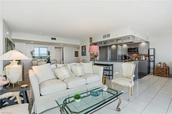 a living room with furniture and a kitchen view
