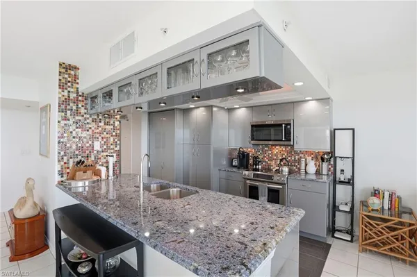a kitchen with granite countertop stainless steel appliances a stove sink and microwave