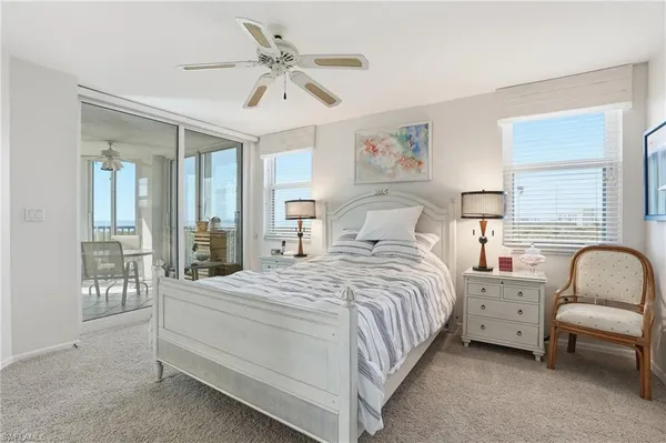 a bedroom with a bed a chandelier and a flat screen television