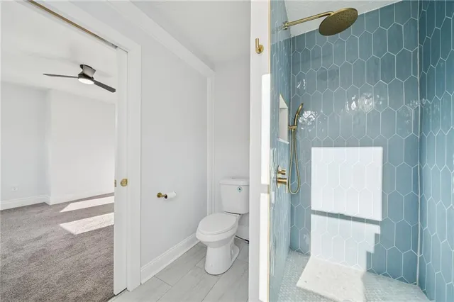 a bathroom with a granite countertop shower and a toilet