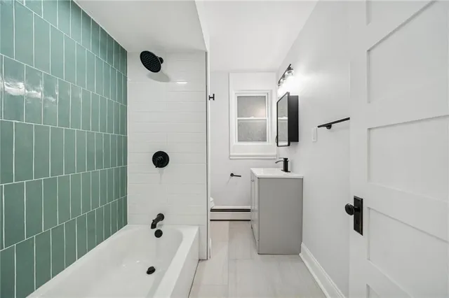 a bathroom with a tub a sink and mirror