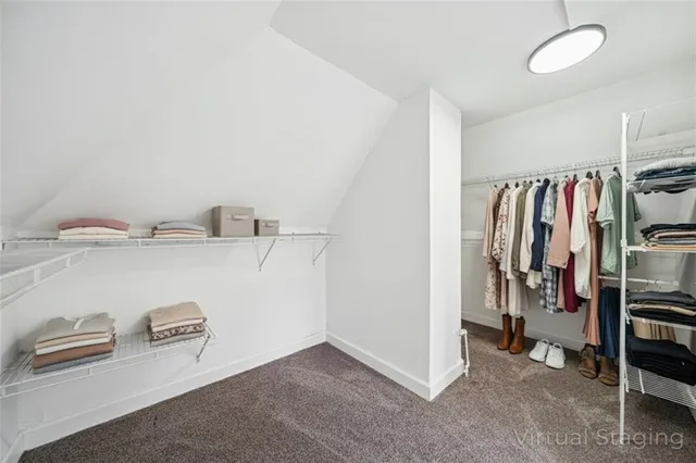 a view of walk in closet with clothes and shoes