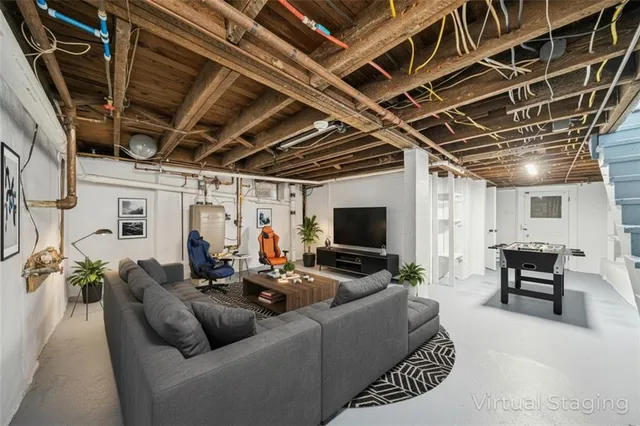 a living room with furniture and a flat screen tv with kitchen view