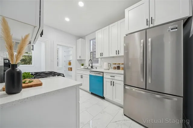 a kitchen with stainless steel appliances a refrigerator sink and white cabinets