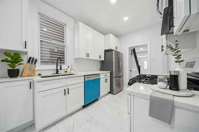 a kitchen with a refrigerator sink and white cabinets