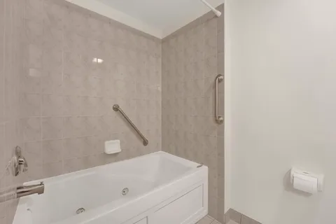 a bathroom with a white bath tub and a shower