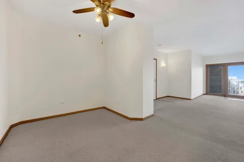 an empty room with a window and a fan
