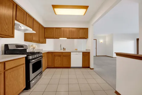 a kitchen with a sink a stove top oven and cabinets