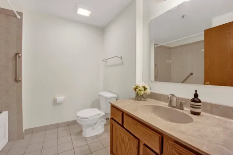 a bathroom with a granite countertop sink a toilet and a mirror