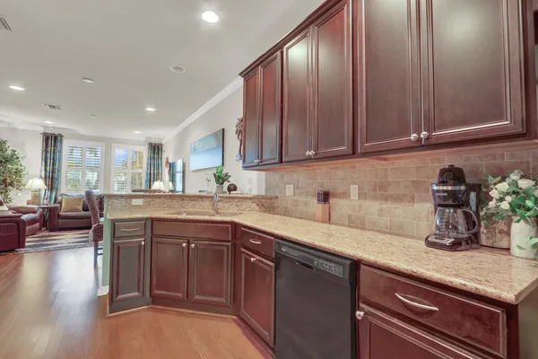 a kitchen with granite countertop stainless steel appliances wooden cabinets and a sink