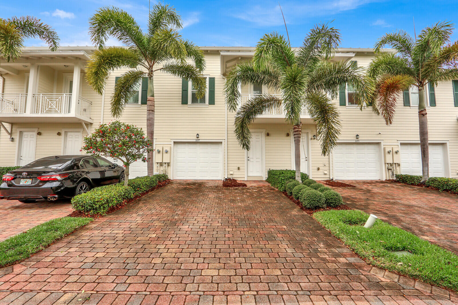 3277 East Mallory Boulevard Jupiter, FL 33458 - Photo 32 of 44 a view of a white house with a yard and palm trees