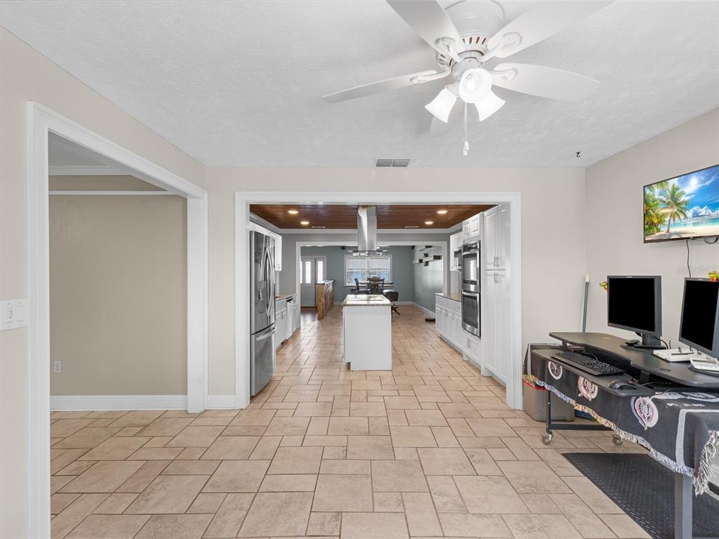 5904 Springrun Court Holiday, FL 34690 - Photo 22 of 53 a hallway with a computer on a table and a chandelier