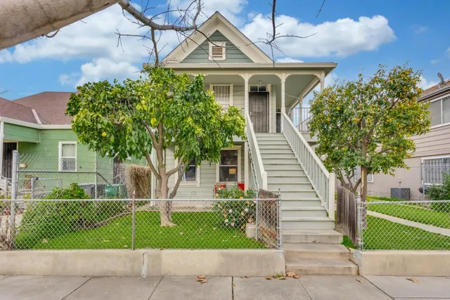 a view of a street with a house and a tree on the side of it