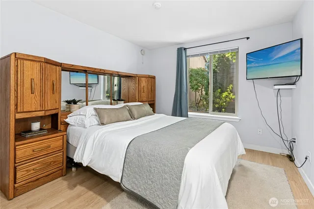 a bedroom with a bed window and flat screen tv