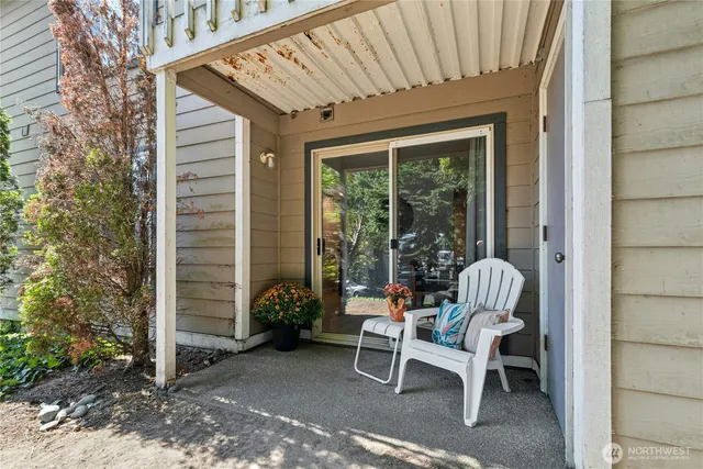 a view of a chair and table in backyard of the house