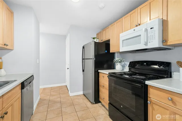 a kitchen with stainless steel appliances granite countertop a stove a refrigerator and a microwave